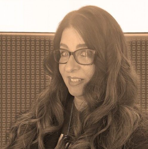 Photo of Poet Marigo J. Stathis Image of a smiling woman with log brown wavy hair and glasses